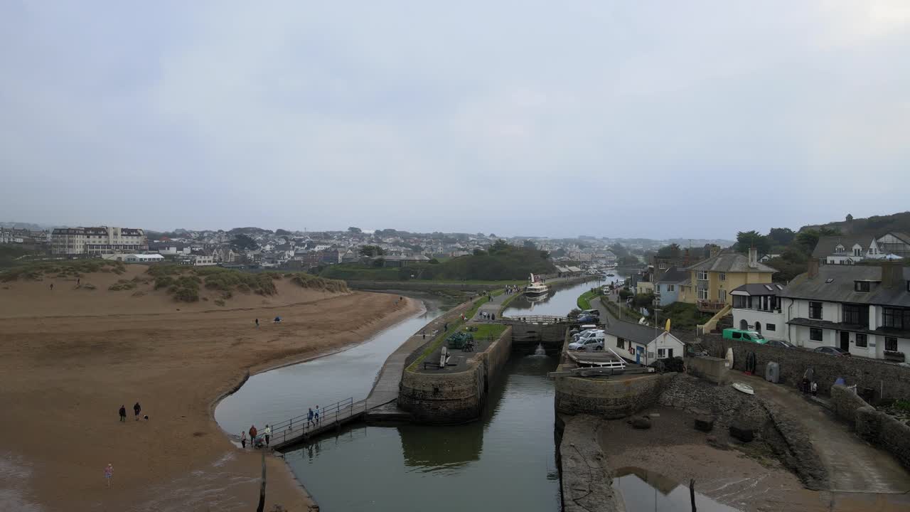 bude cornwall canal y bloqueo de imágenes aéreas 4k personas cruzan un pequeño puente drone a lo largo del canal pasando barco amarrado