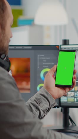 vertical video video editor talking on video call holding smartphone with green screen