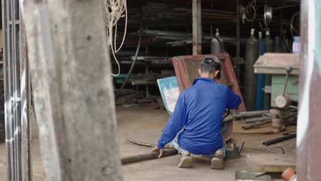 a man is cutting metal in a workshop, creating sparks
