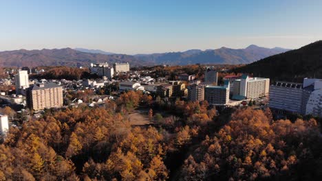 lento avance aéreo sobre la hermosa ciudad turística japonesa, kusatsu onsen durante el otoño