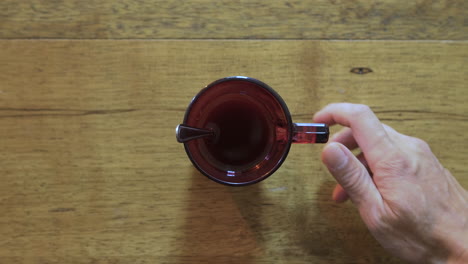 mano derecha de un hombre promedio blanco poniendo directamente una taza de café