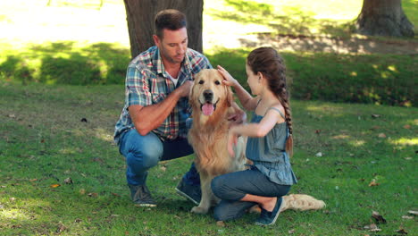 father and daughter with their pet dog in the park