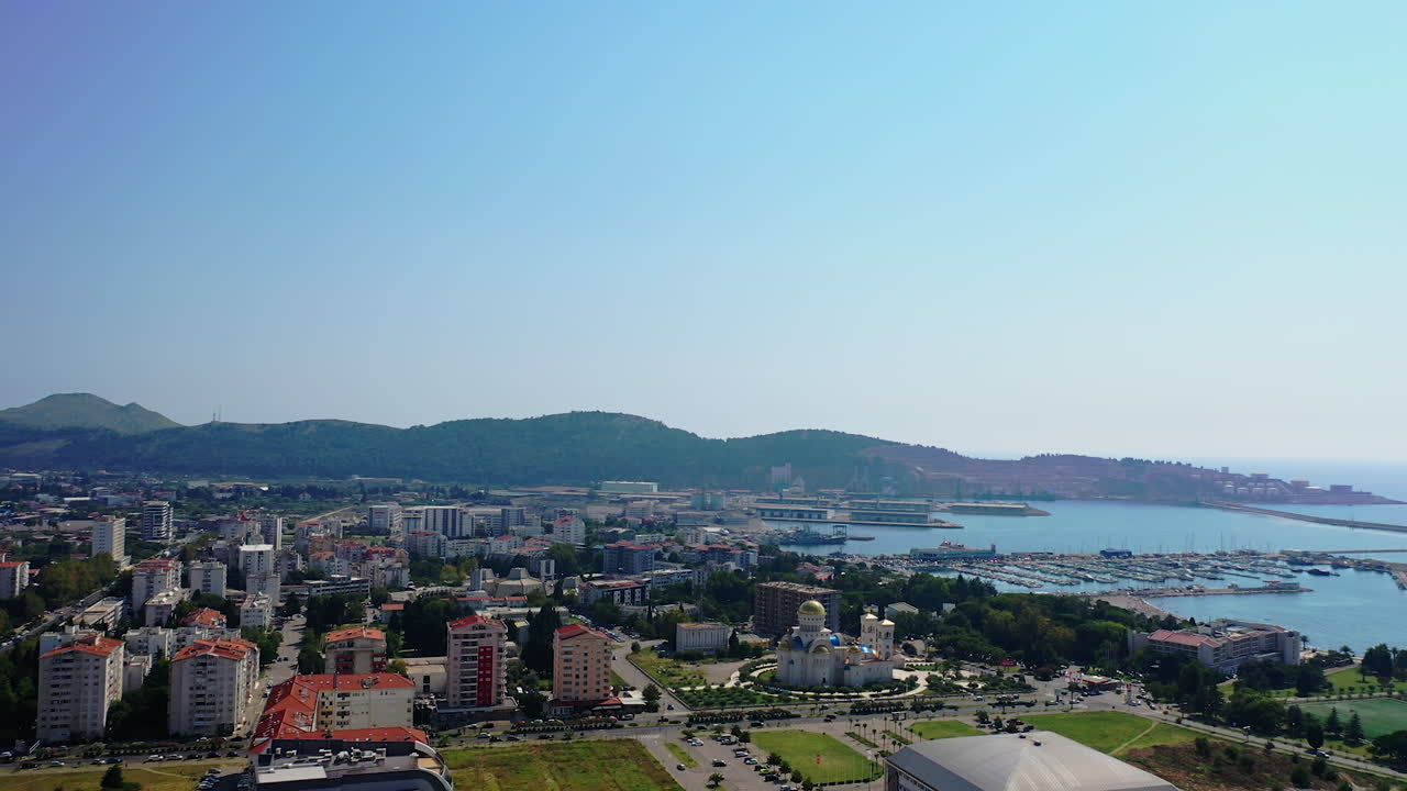 Modern resort city at the shore of Adriatic Sea. Drone footage above the cityscape and waterscape. Bar, Montenegro from aerial view.