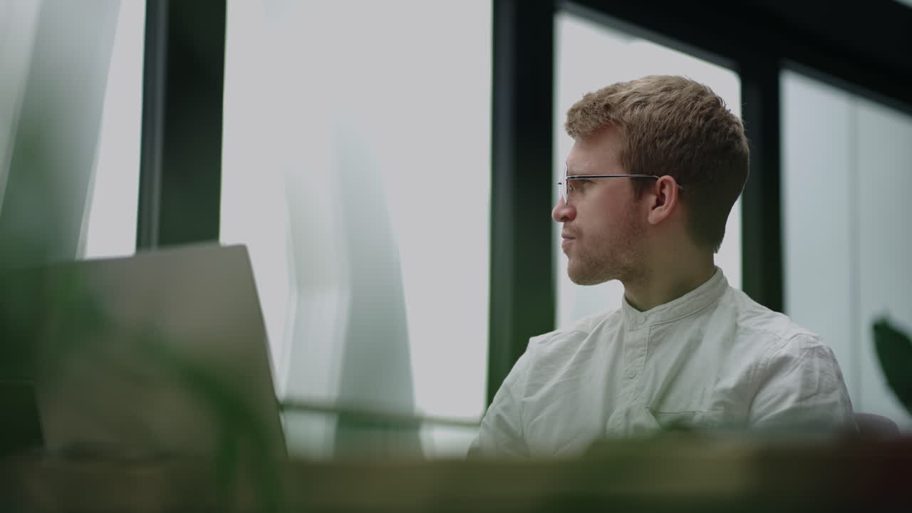 financial specialist or businessman is looking at screen of laptop in his office working and reading news