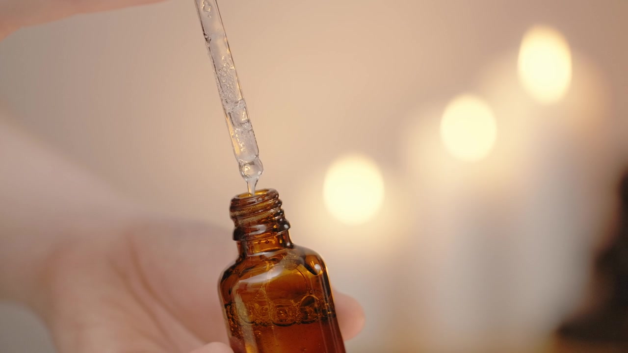 Person Using Dropper with Amber Glass Bottle