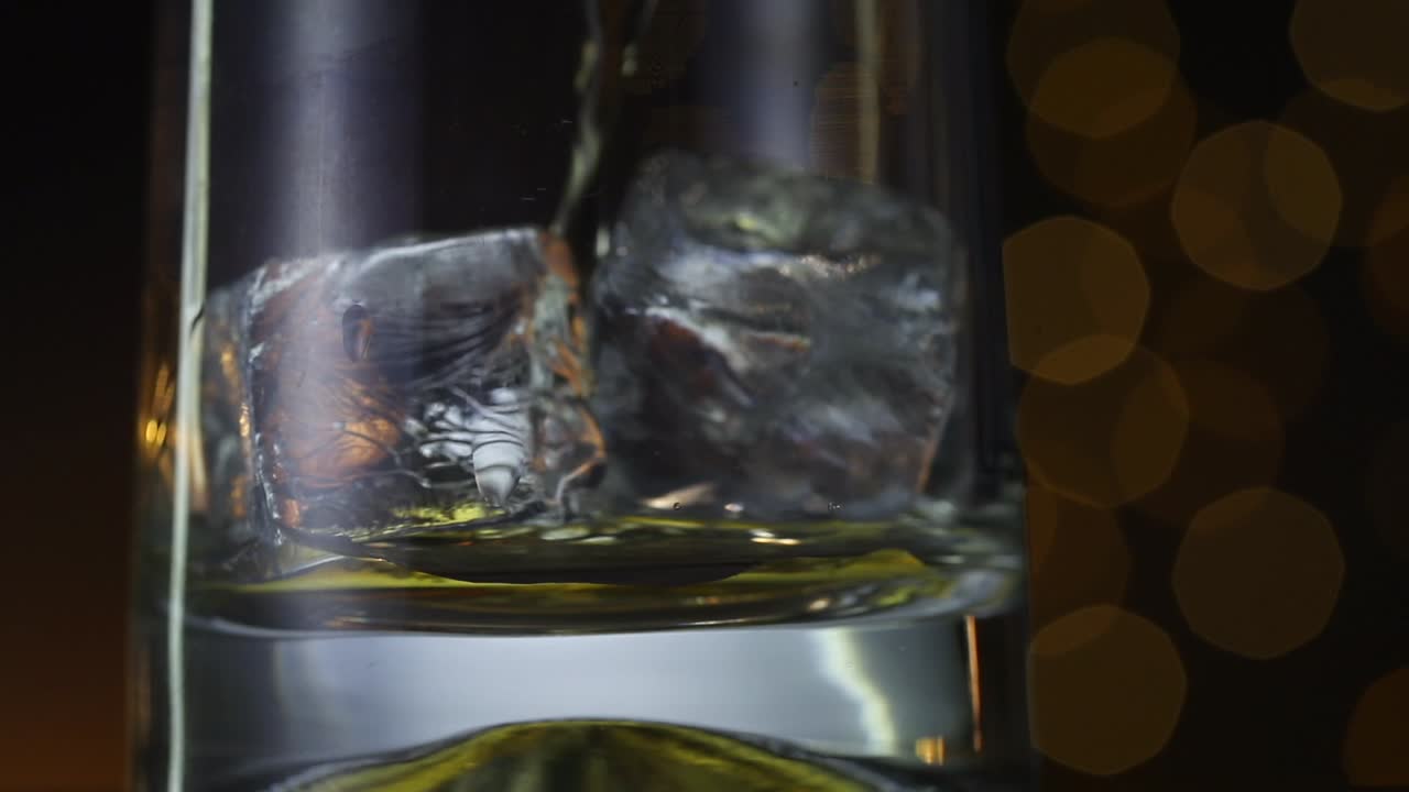 whisky vertido sobre cubos de hielo