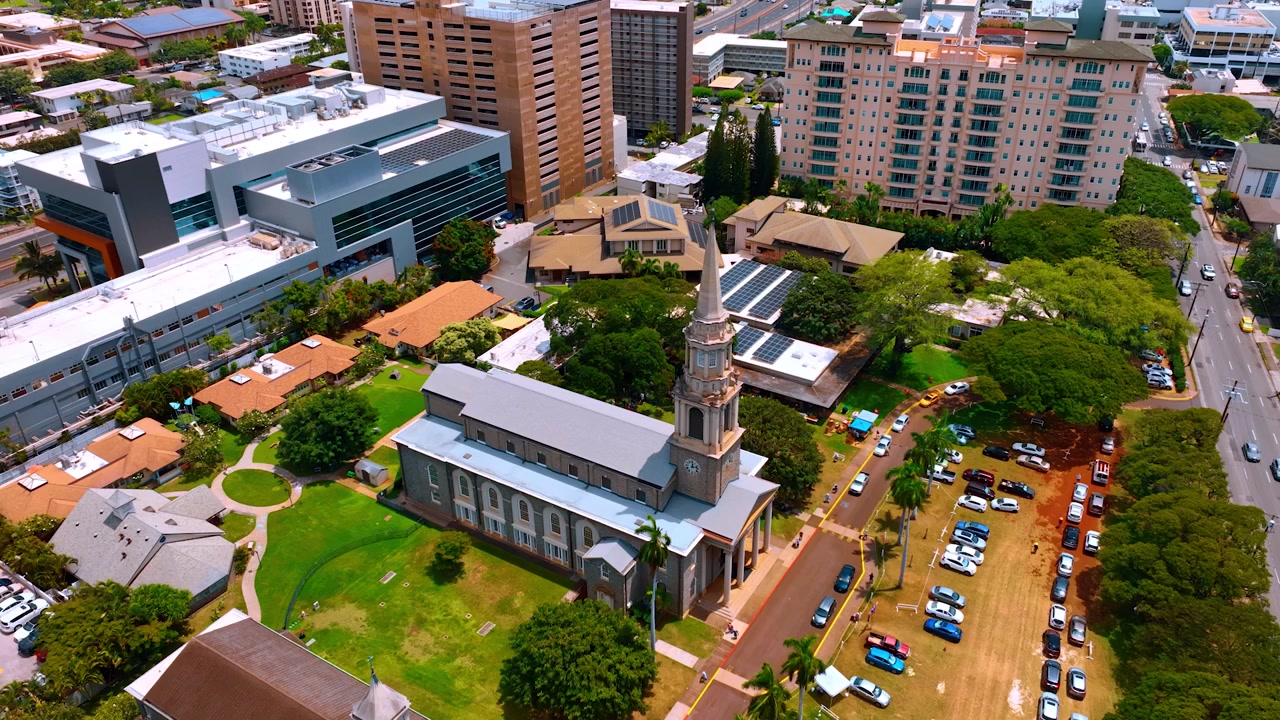 Central union Church of Honolulu from top perspective. Drone approaching the tower clock at the building.