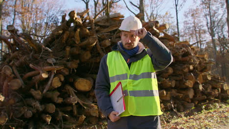 safety conscious tree specialist, background of felled tree trunks