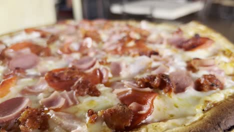 una toma estabilizada de una deliciosa pizza de pepperoni llena de queso.