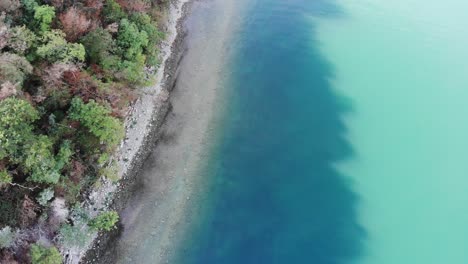 drone-flies-over-Monte-isola-shore-during-a-sunny-autumn-day-showing-the-amazing-water-colors