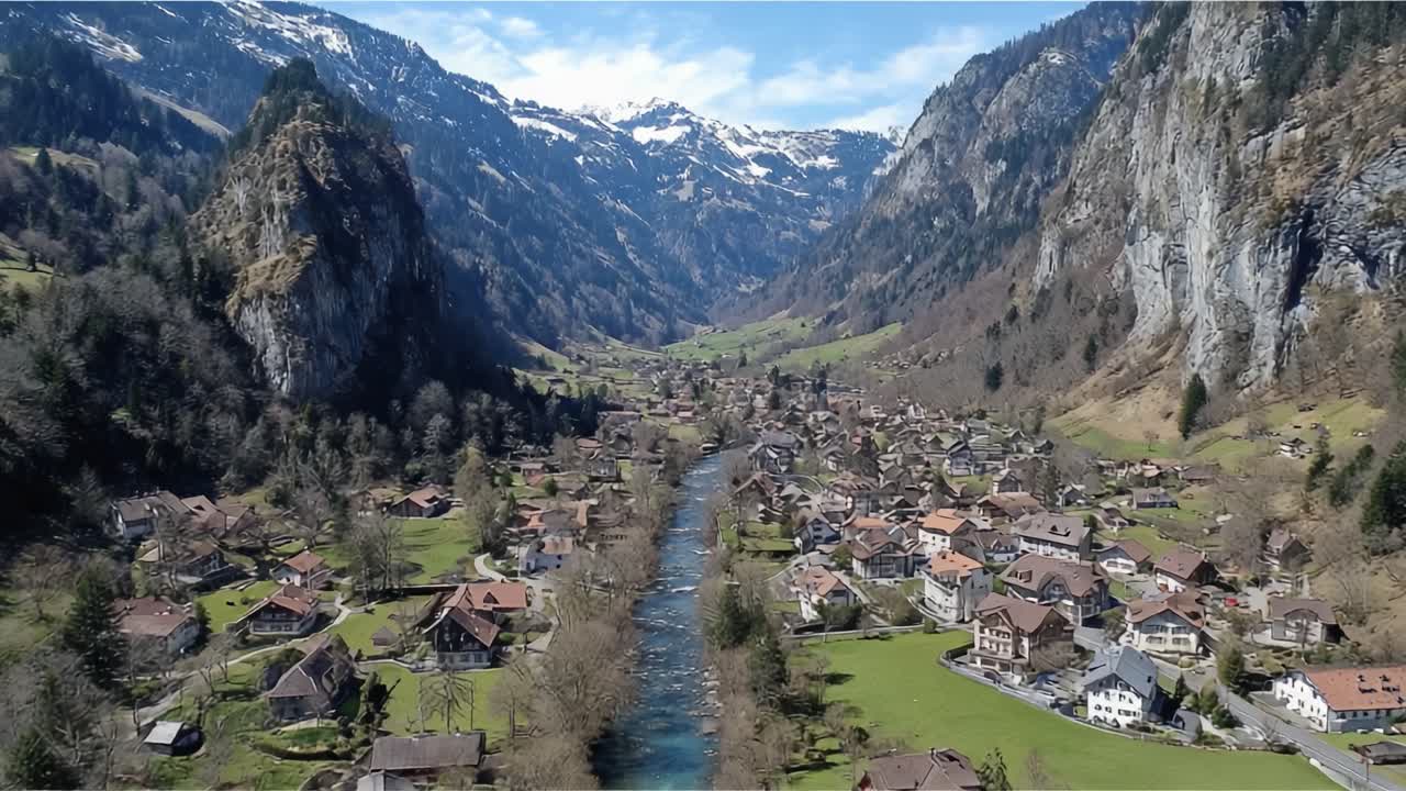 Panoramische Luftaufnahme eines malerischen Tals, umgeben von majestätischen Bergen und üppigem Grün, mit einem ruhigen Fluss, der durch charmante Dörfer fließt