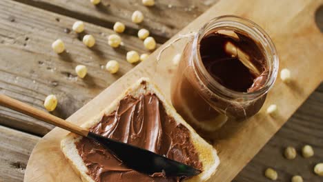 video of close up of toast with chocolate cream on wooden background