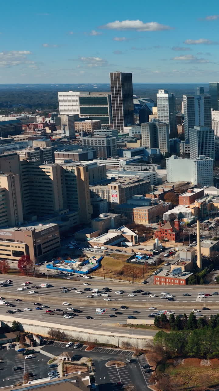 Atlanta, Georgia, USA - January 02, 2024: A drone flying along an interstate with cars. Downtown with a view of Mercedes-Benz Stadium. Vertical video