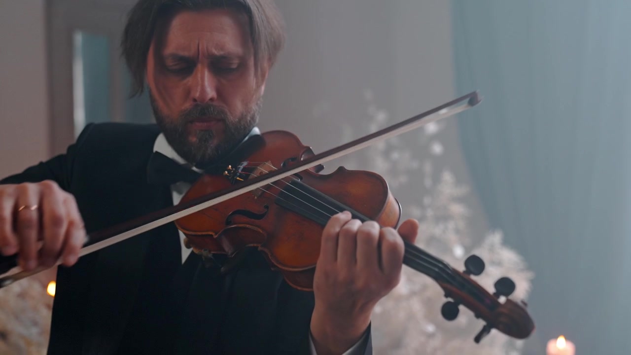 Primo piano di un uomo in abito formale che suona il violino