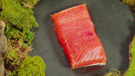 smoked salmon on a slate plate with moss