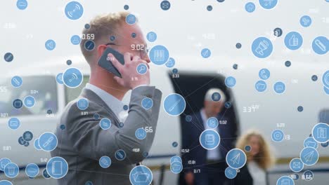 animation of icons over caucasian businessman with smartphone and private plane