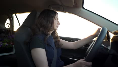 portrait of beautiful woman driving car sunset sun rays shine through car window