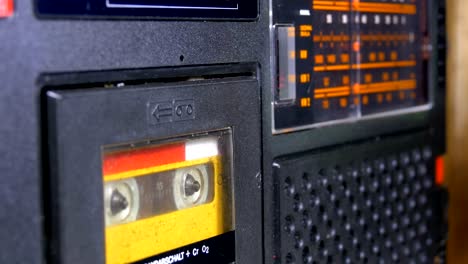 the vintage yellow audio cassette in the old tape recorder rotates