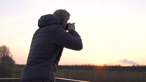 a person is taking photos while standing on a viewing platform