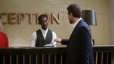 young man completing his check-in at the hotel