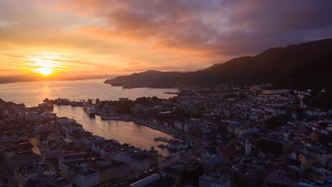 Disparo-De-Drones-Volando-Sobre-Bergen-Hacia-El-Famoso-Punto-De-Referencia,-Bryggen,-En-Una-Hermosa-Puesta-De-Sol