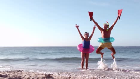 happy senior couple jumping with hands up