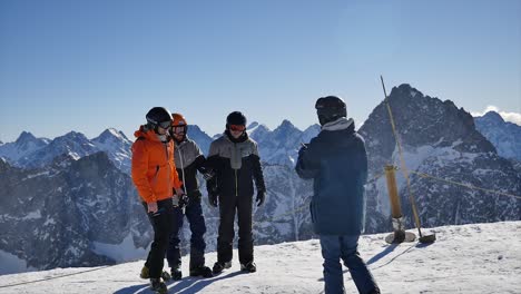 tourist group having their photo taken with a backdrop of snow covered mountains, phone picture of three people with one person taking their photo