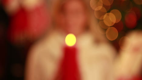 pretty blonde holding candle at christmas