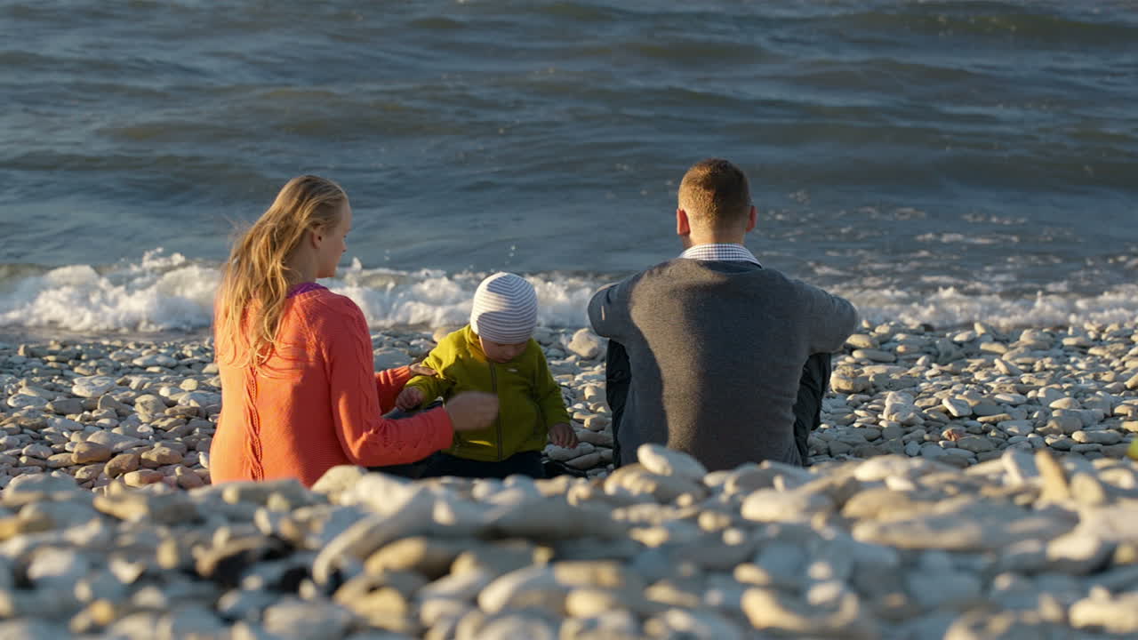 Family of three on pebble beach