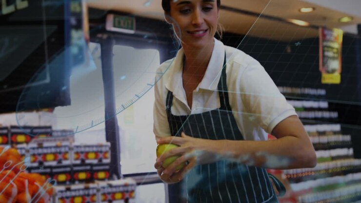 Inquadratura che si allarga mostrando un commesso del reparto frutta e verdura che seleziona frutta gialla per l'esposizione al dettaglio, con un effetto lente sovrapposto.