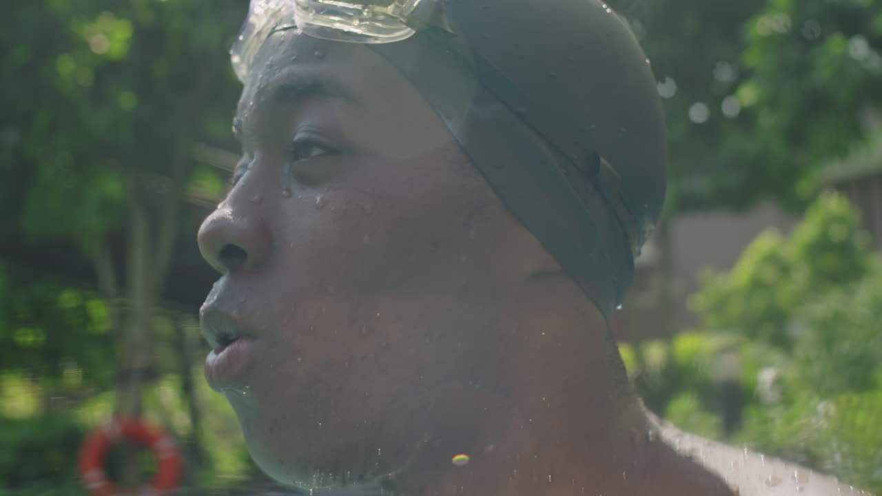 Black Man Taking Off Swimming Goggles in Pool