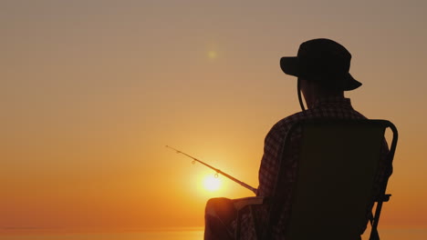 A-Young-Man-Is-Sitting-On-The-Seashore-Fishing-Relaxing-In-The-Open-Air-4K-Video