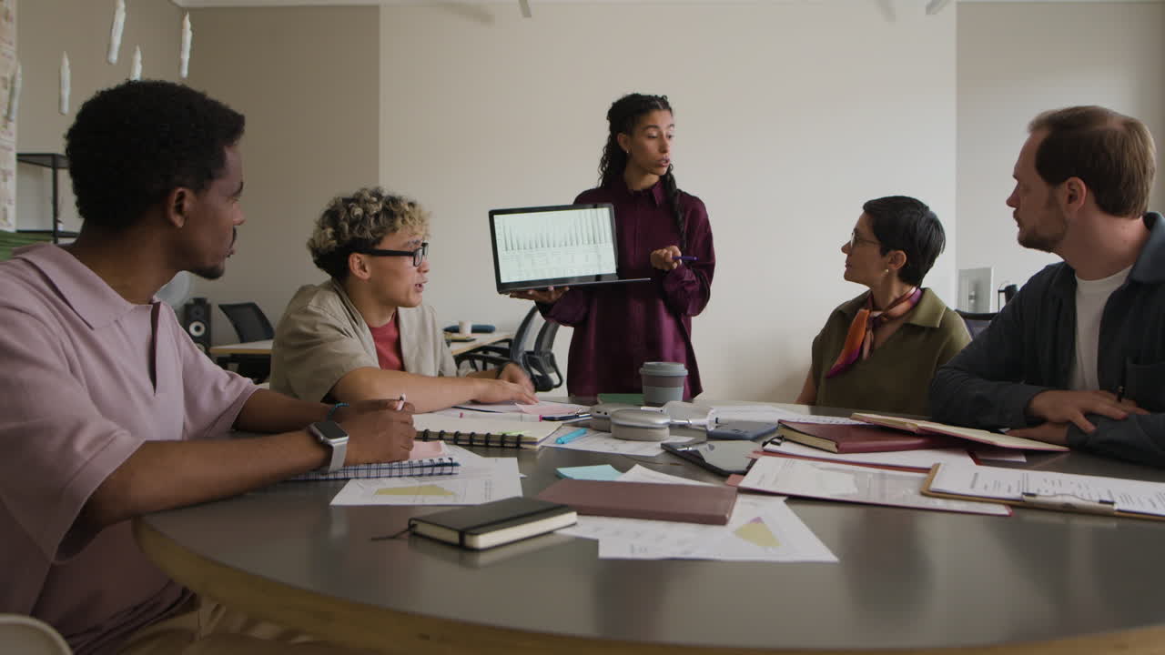 Diverse Business Professionals Collaborating in a Meeting with Laptop Presentation