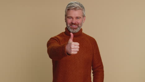 middle-aged man raises thumbs up agrees or gives positive reply recommends advertisement likes good