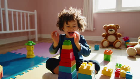 happy child playing with building blocks in a playroom