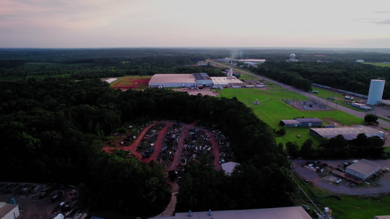 Aerial Shot of Rural Industrial Park with Large Vehicle Scrap Junkyard and Highway. Alabama, USA
