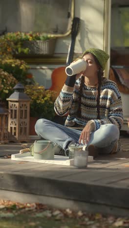 woman enjoying a warm drink outdoors by a camper