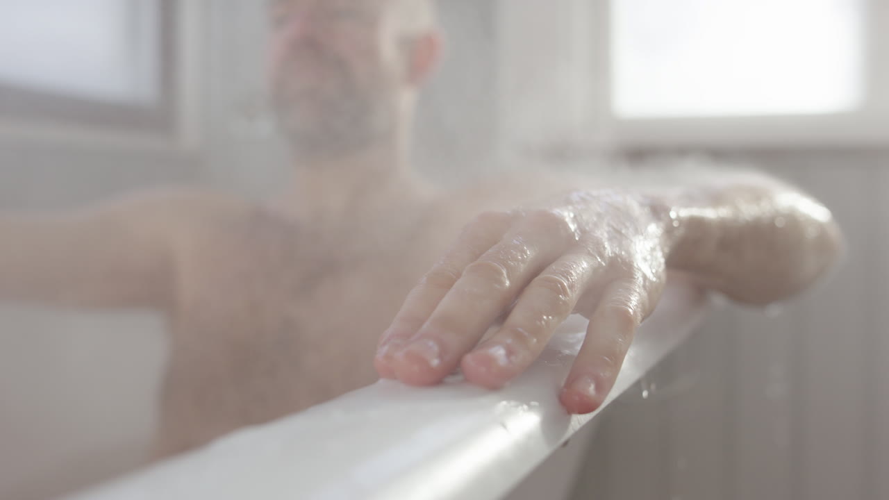 Man enjoys rejuvenating hot steam bath after long day's work, closeup slomo
