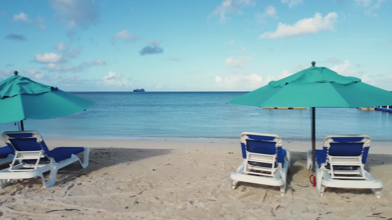 Panoramica in primo piano di lettini e ombrelloni da spiaggia.