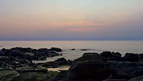 lapso de tiempo de puesta de sol de playa rocosa con nubes dispersas