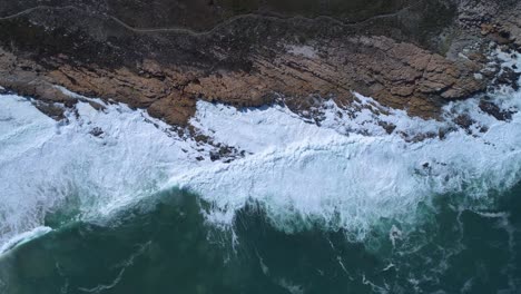 aerial of waves breaking on rugged south african coastline, kleinmond, overstrand, south africa