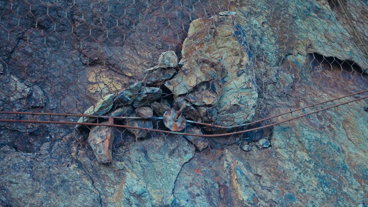 Metal Wire Mesh Stretches Across Rugged Coastal Rocks, Showing Weathered Textures Shaped by the Harsh Northern Environment in Strøksnes, Sørfold Municipality, Nordland, Norway - Close Up