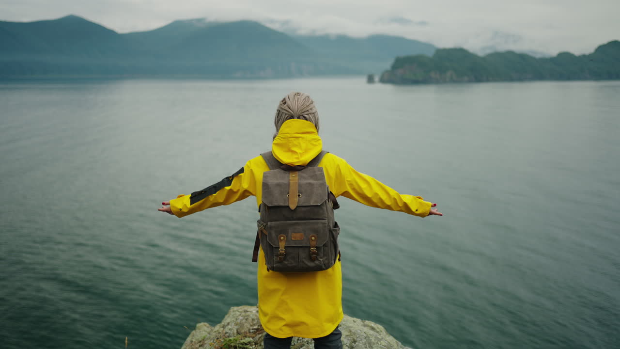 Woman Hiking on Coastal Cliff with Rain Jacket
