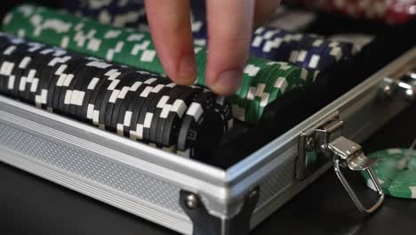 extreme slo mo of a person picking up poker markers from a case