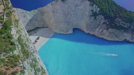 aerial over boat in zakynthos greece navagio shipwreck cove with blue water