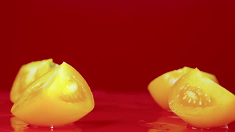 yellow tomato halves on red background