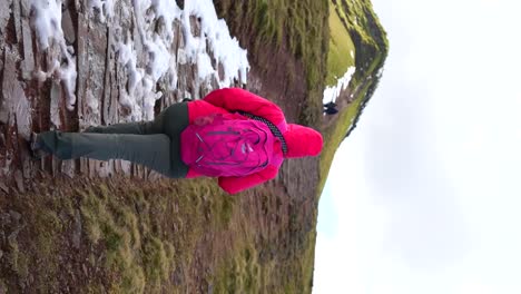 Hiker-climbing-snowy-trail-in-the-Welsh-Mountains,-view-from-behind