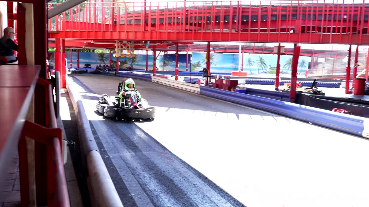 Persona che guida un go-kart su una pista da corsa coperta