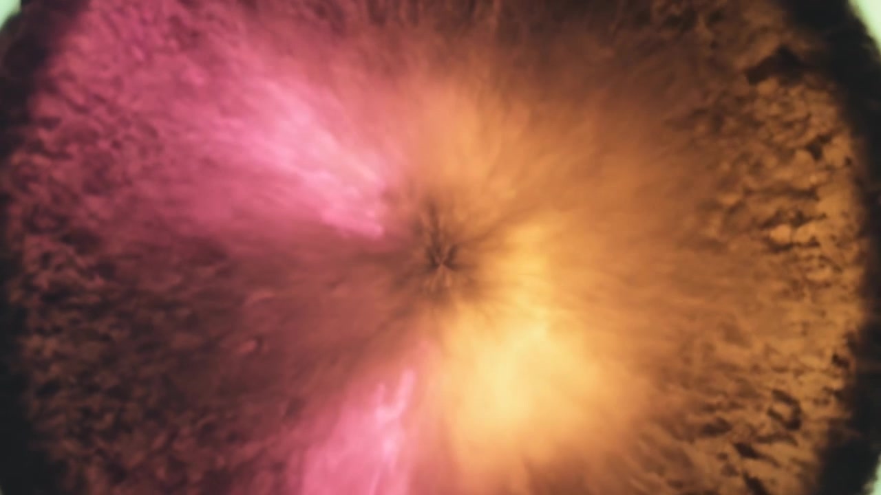 Starting spot driving disc pattern pulsing, spreading in macro closeup, forming pink-gold lobes