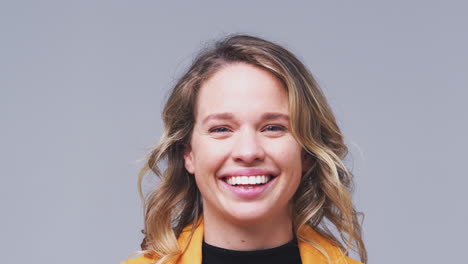 Close-Up-Head-And-Shoulders-Studio-Shot-Of-Woman-Laughing-At-Camera-In-Slow-Motion